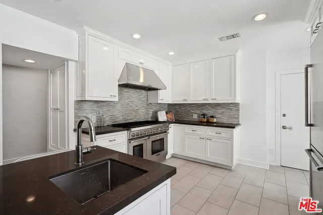 a kitchen with stainless steel appliances a stove a sink and a refrigerator