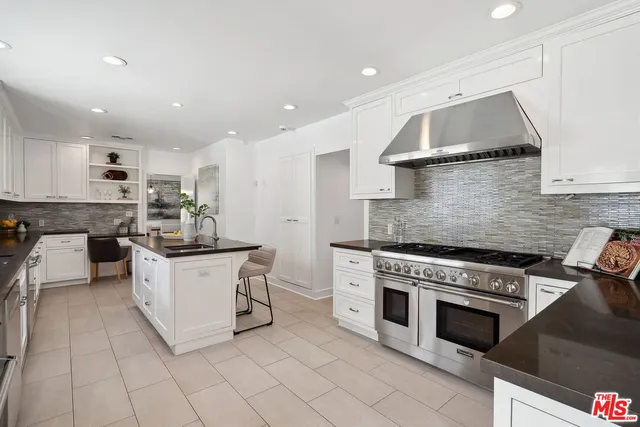 a kitchen with stainless steel appliances kitchen island granite countertop a sink and cabinets
