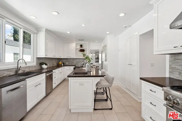 a kitchen with stainless steel appliances granite countertop a sink and cabinets