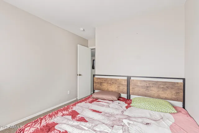 a bedroom with a bed and a painting on the wall