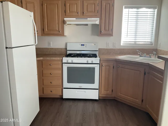 a kitchen with a stove sink and refrigerator