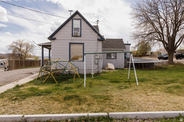 197 West 100 South Redmond, UT 84652 - Photo 4 of 41 Rear view of house with a trampoline, a shingled roof, and a chimney