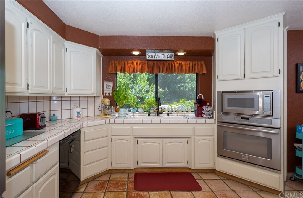 47810 Bee Canyon Truck Trail Hemet, CA 92544 - Photo 19 of 43 a kitchen with a stove window and cabinets