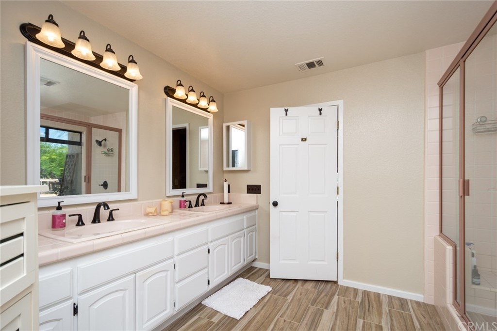 47810 Bee Canyon Truck Trail Hemet, CA 92544 - Photo 23 of 43 a bathroom with a double vanity sink and mirror with shower