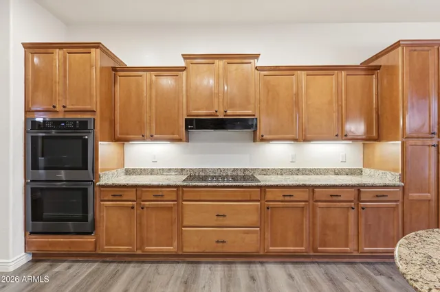 a kitchen with stainless steel appliances granite countertop a kitchen island a stove a refrigerator and a sink