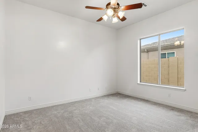 an empty room with fan and entrance
