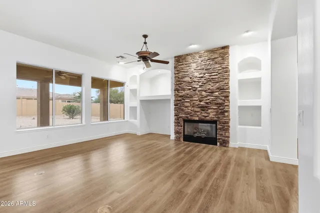 a view of empty room with fireplace and wooden floor