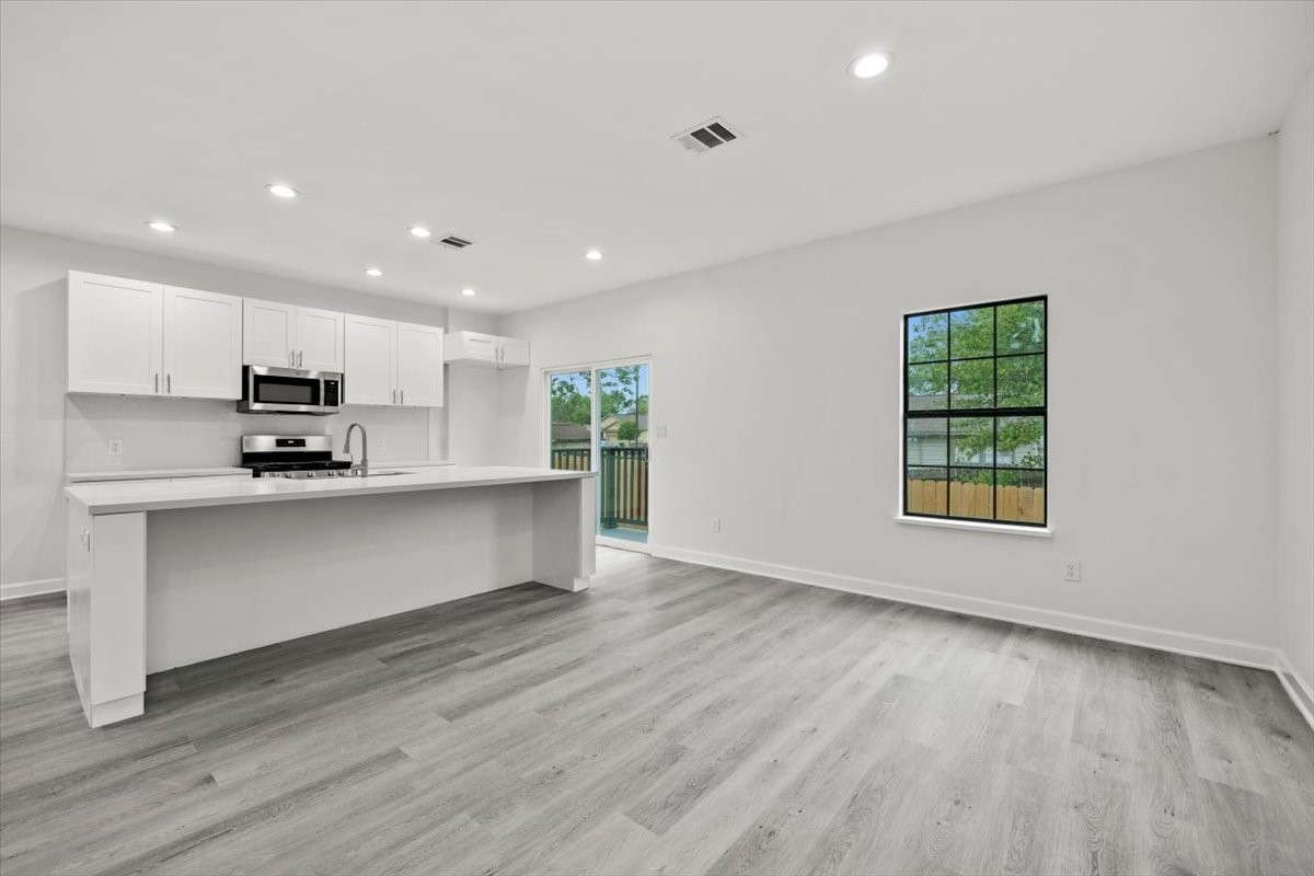727 East 40th Street Houston, TX 77022 - Photo 6 of 22 a kitchen with stainless steel appliances a refrigerator sink and cabinets