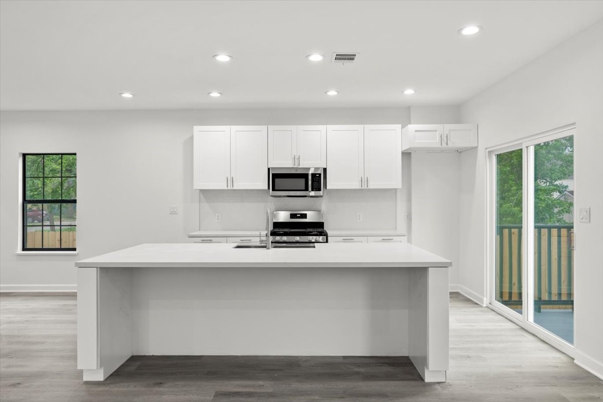 727 East 40th Street Houston, TX 77022 - Photo 7 of 22 a kitchen with kitchen island white cabinets and stainless steel appliances