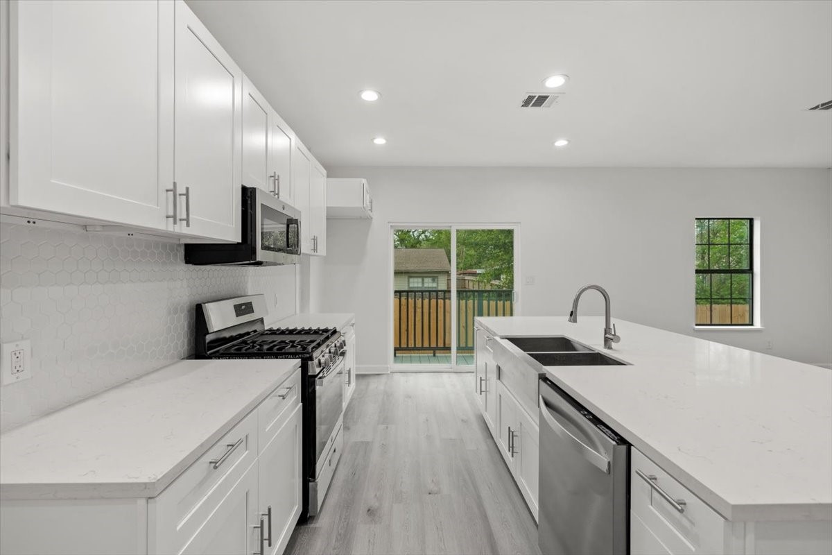 727 East 40th Street Houston, TX 77022 - Photo 8 of 22 a kitchen with stainless steel appliances granite countertop a sink a stove and a refrigerator