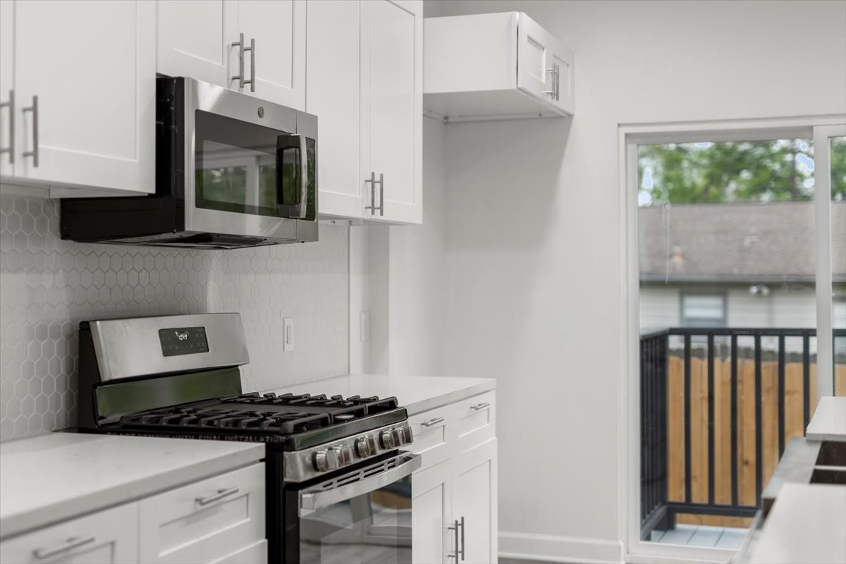 727 East 40th Street Houston, TX 77022 - Photo 9 of 22 a kitchen with stainless steel appliances granite countertop a stove and a microwave