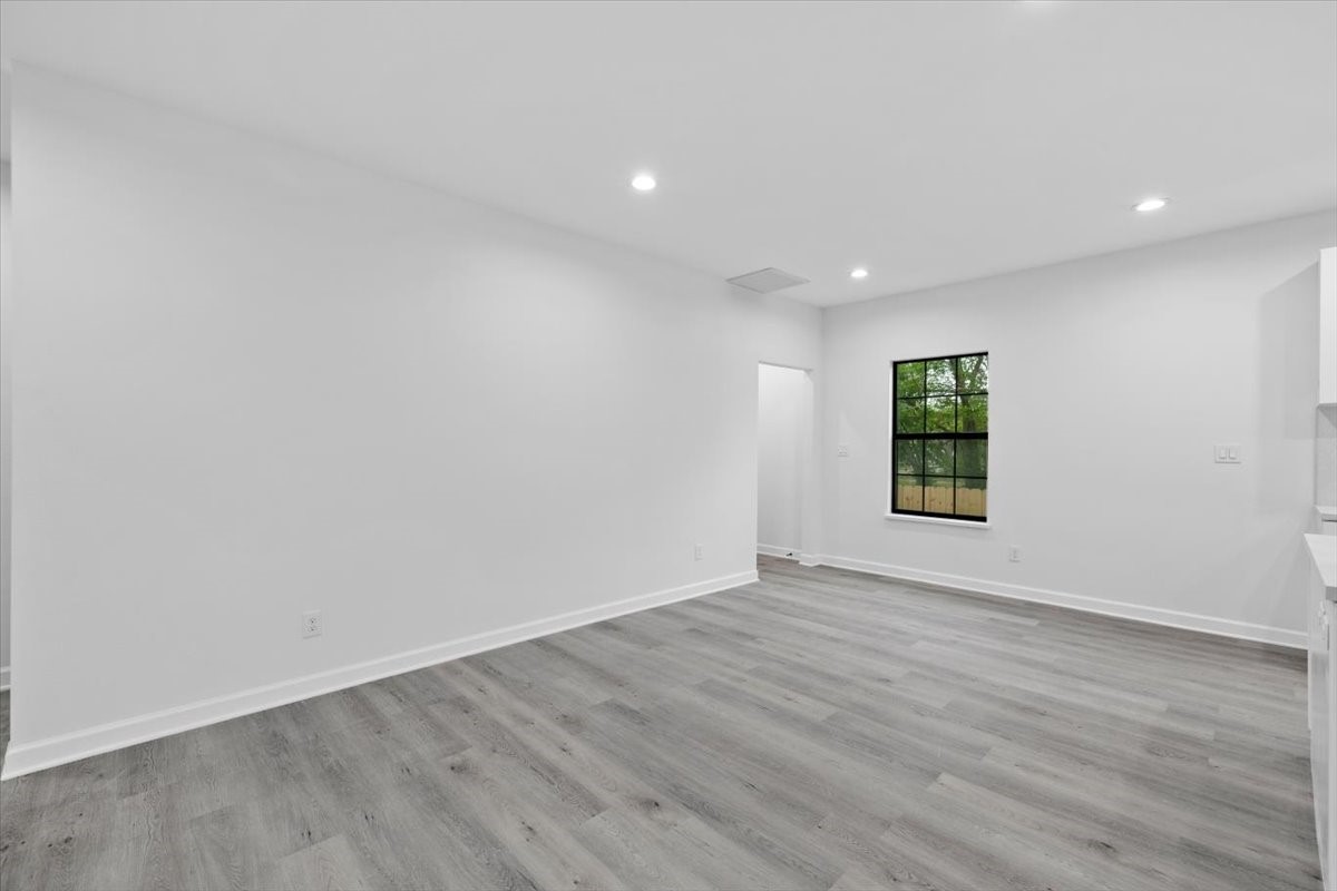 727 East 40th Street Houston, TX 77022 - Photo 10 of 22 a view of an empty room with wooden floor and a window