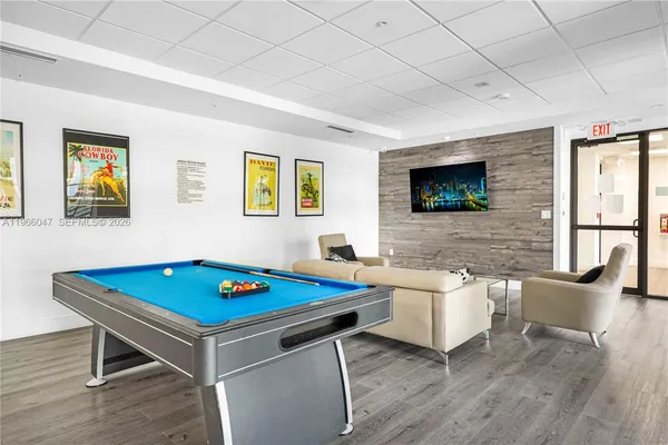 a living room with a table chairs and a flat screen tv