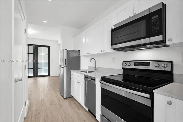 a kitchen with stainless steel appliances granite countertop a stove microwave and refrigerator