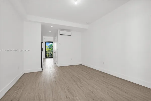 an empty room with wooden floor & windows