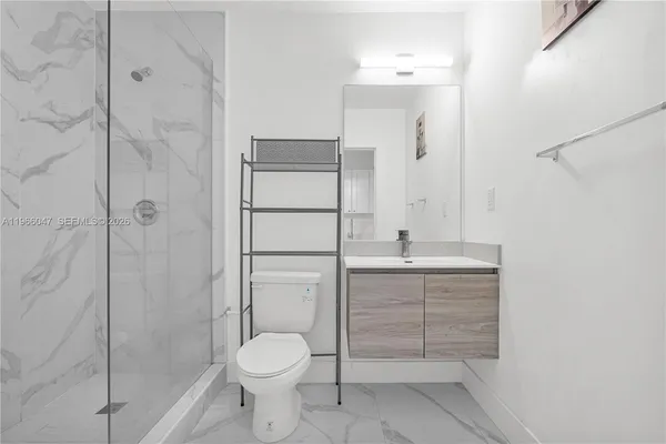 a bathroom with a granite countertop sink toilet and shower