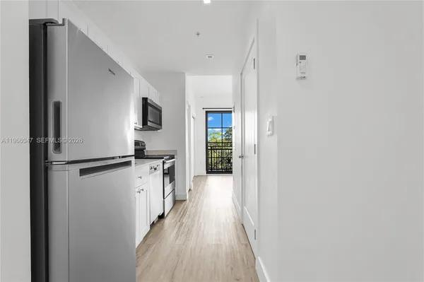 a view of a hallway with wooden floor