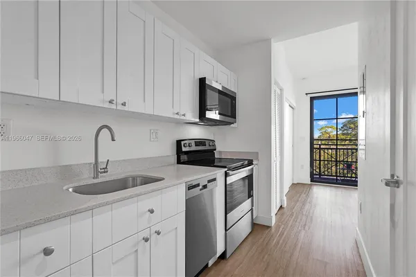 a kitchen with stainless steel appliances granite countertop a sink stove and cabinets