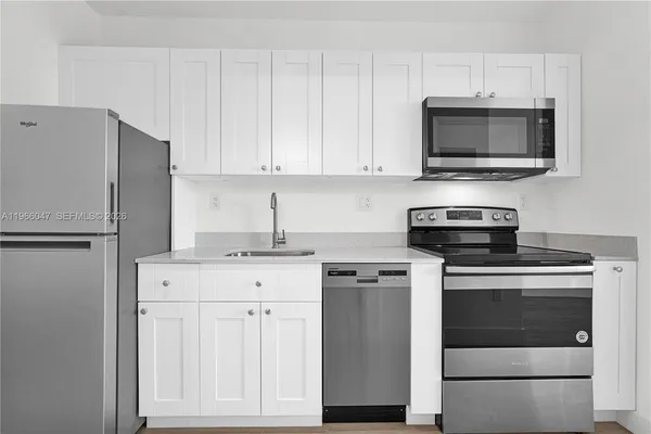 a kitchen with white cabinets and stainless steel appliances