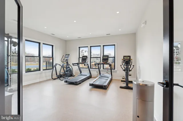 a living room with furniture gym equipment and a large window