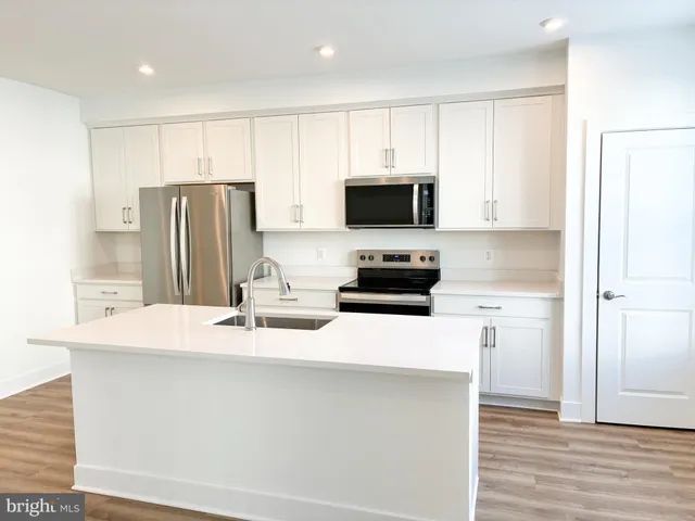 a kitchen with stainless steel appliances a refrigerator microwave stove top oven and sink