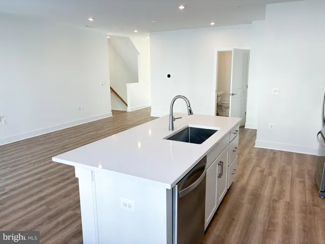 a kitchen with kitchen island a sink and wooden floor