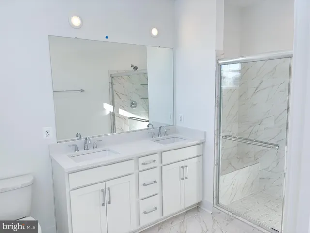 a bathroom with a granite countertop sink a toilet and a mirror