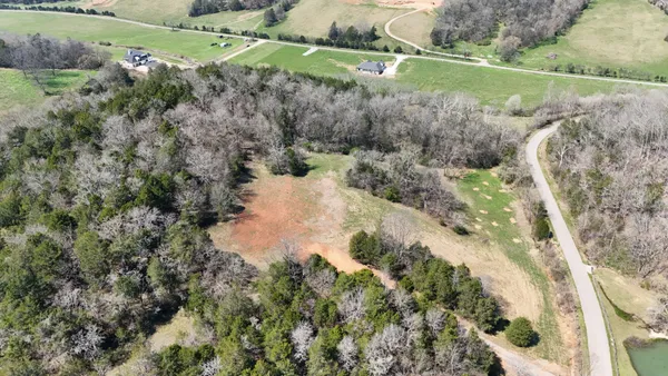 an aerial view of a house with a yard and lake