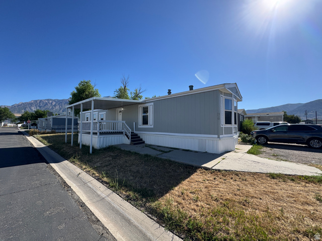 2491 Highway 89, Unit 315 Pleasant View, UT 84404 - Photo 6 of 34 Light blue siding exterior featuring a covered front porch with white railing