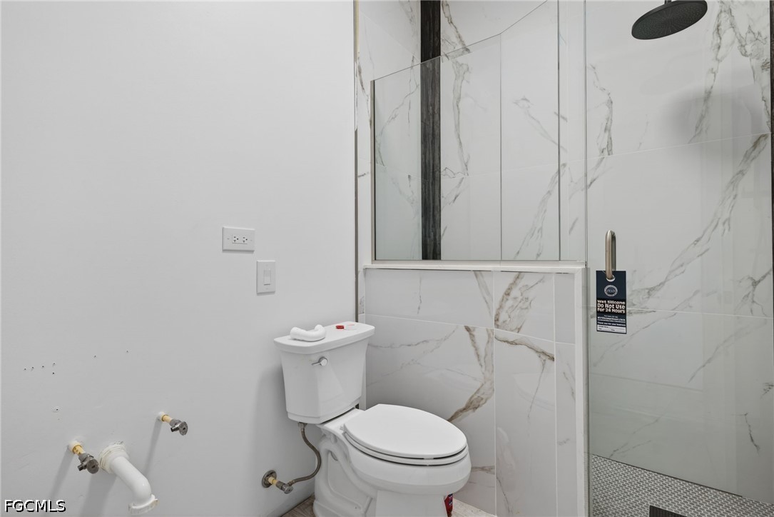 2665 Oil Well Road Naples, FL 34120 - Photo 25 of 40 a white toilet sitting next to a bathroom sink