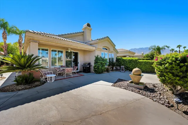 a view of a house with sitting area and garden
