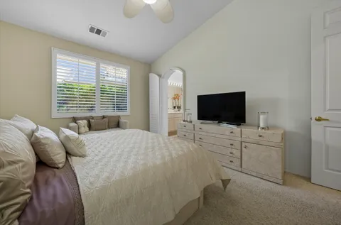 a large bedroom with a bed and flat screen tv