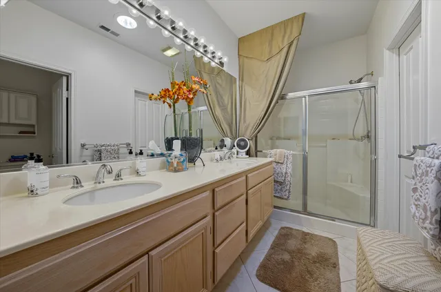 a spacious bathroom with a double vanity sink mirror and shower
