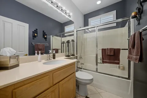 a bathroom with a sink a toilet a mirror and shower
