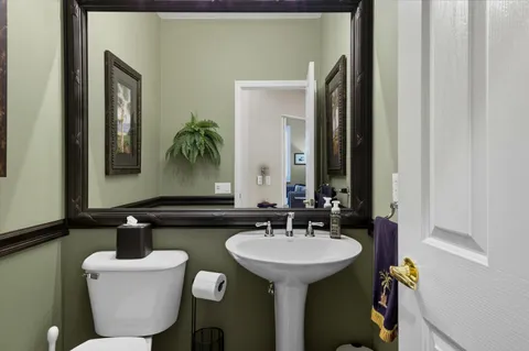 a bathroom with a toilet sink and mirror