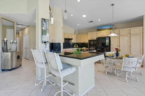 a kitchen with stainless steel appliances kitchen island granite countertop a sink and cabinets