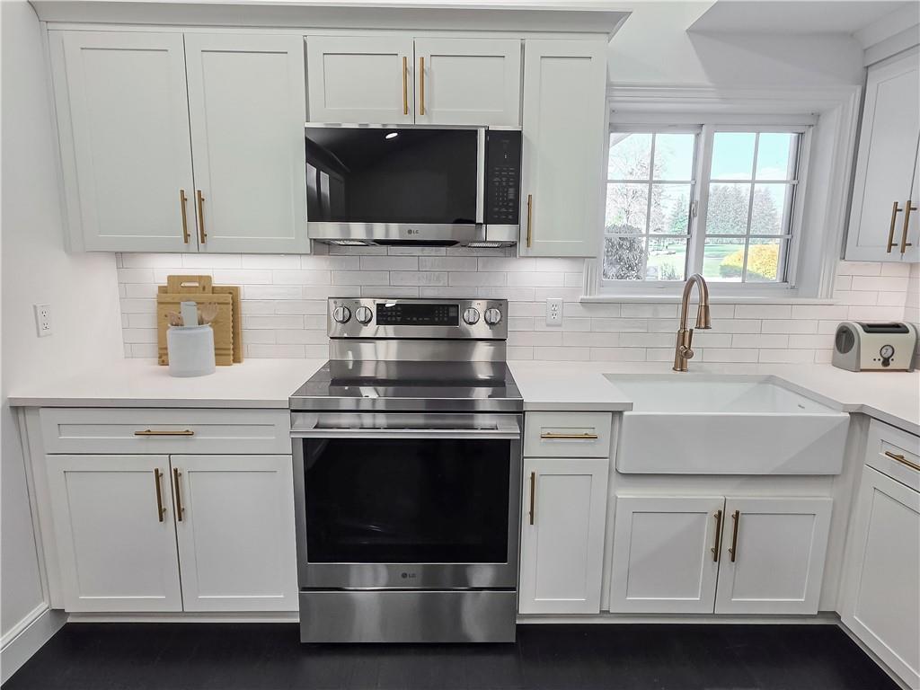 11753 Oakview Road Conneaut Lake, PA 16316 - Photo 10 of 34 a kitchen with white cabinets stainless steel appliances and sink