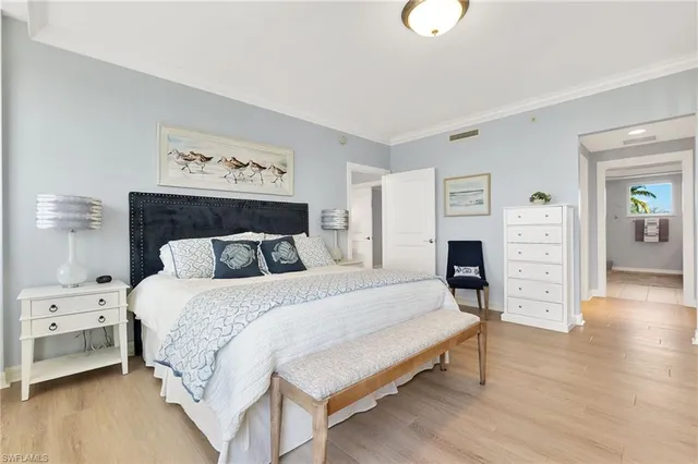 a spacious bedroom with a bed and wooden floor