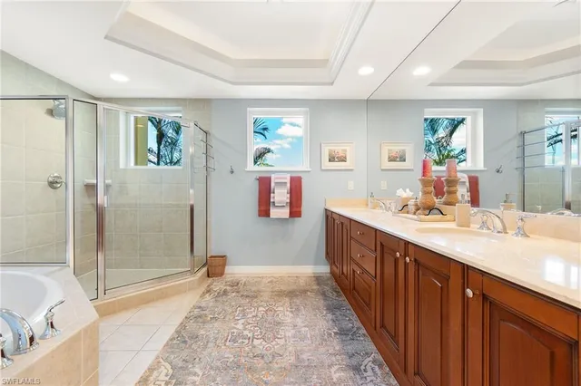 a spacious bathroom with a sink a mirror a bathtub and shower