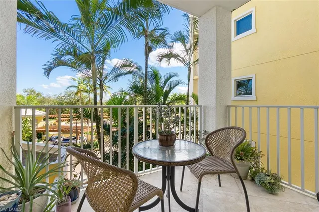 a view of a balcony with chairs and a potted plant