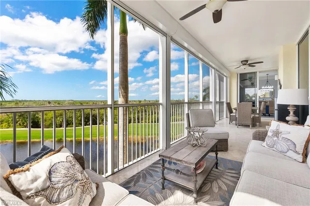 a living room with furniture and a floor to ceiling window