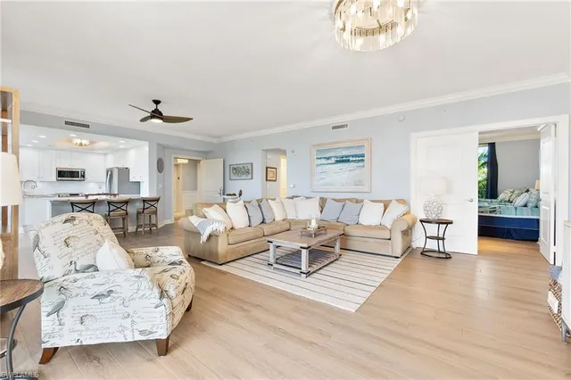 a living room with furniture and a large mirror with wooden floor