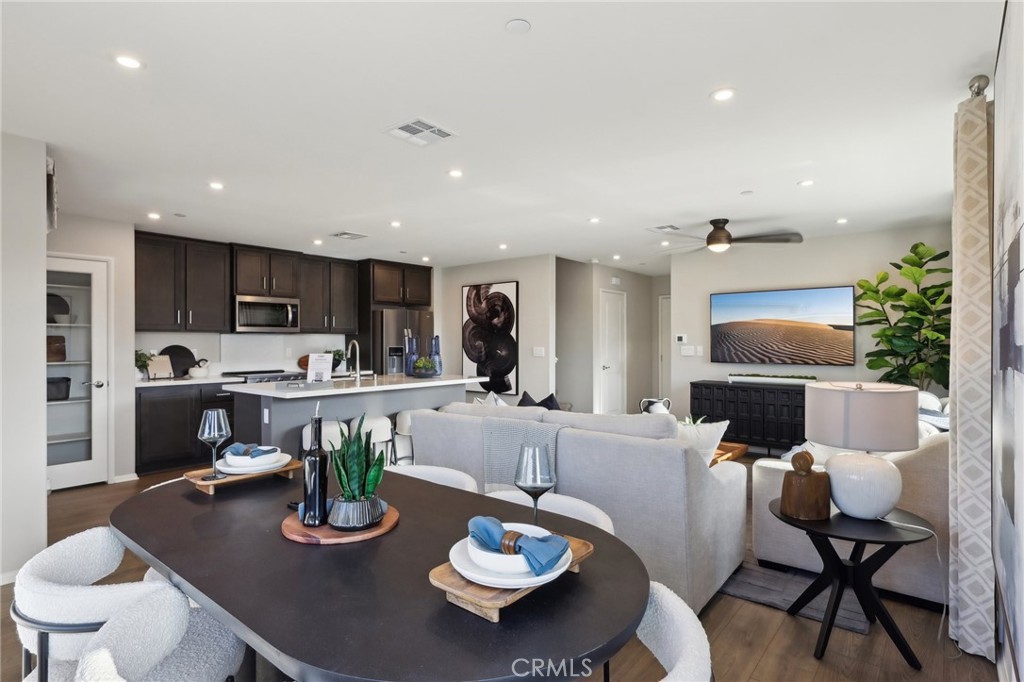 15535 April Dawn Way, Unit 1 Fontana, CA 92336 - Photo 3 of 16 a living room with furniture kitchen view and a wooden floor