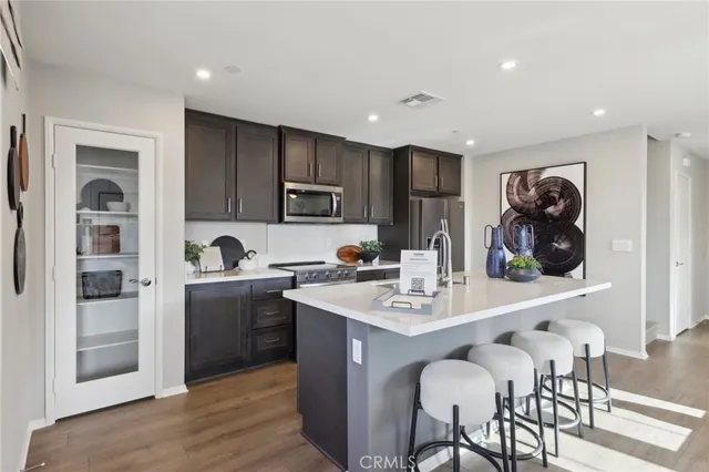 a kitchen with stainless steel appliances granite countertop a refrigerator and a stove top oven