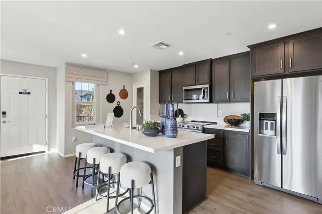 a kitchen with refrigerator cabinets and wooden floor