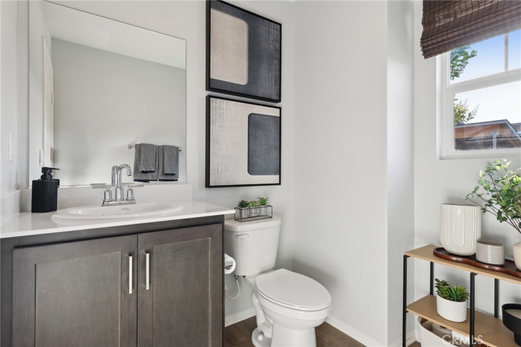 15535 April Dawn Way, Unit 1 Fontana, CA 92336 - Photo 7 of 16 a bathroom with a toilet sink and mirror