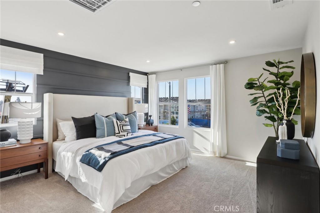 15535 April Dawn Way, Unit 1 Fontana, CA 92336 - Photo 8 of 16 a bedroom with a bed and a potted plant