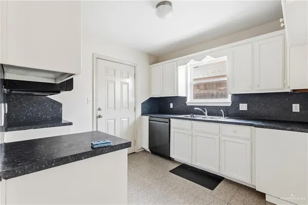 a kitchen with granite countertop a sink stove and cabinets