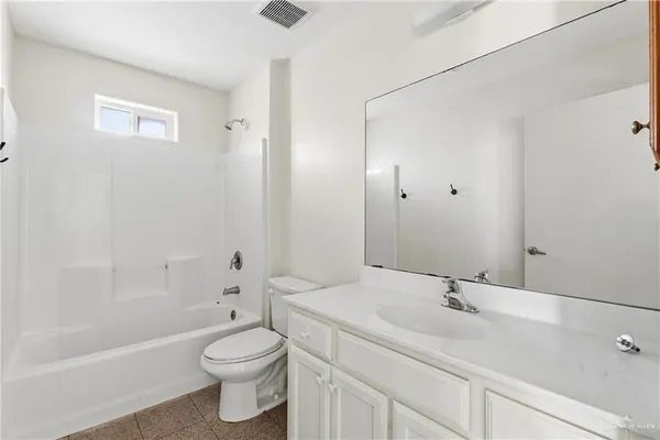 a bathroom with a sink a toilet and a large mirror