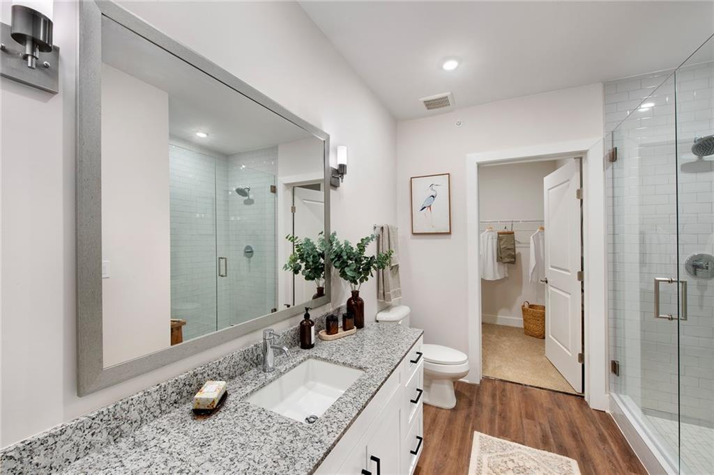1545 Whitemarsh Road, Unit A2 Kennesaw, GA 30152 - Photo 44 of 46 a bathroom with a granite countertop sink a toilet a mirror and shower
